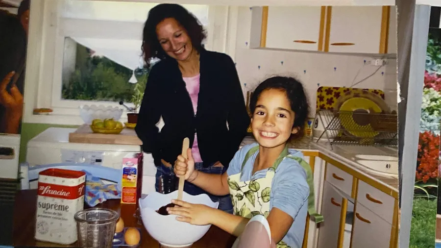 Woman and smiling girl baking together in a cosy kitchen