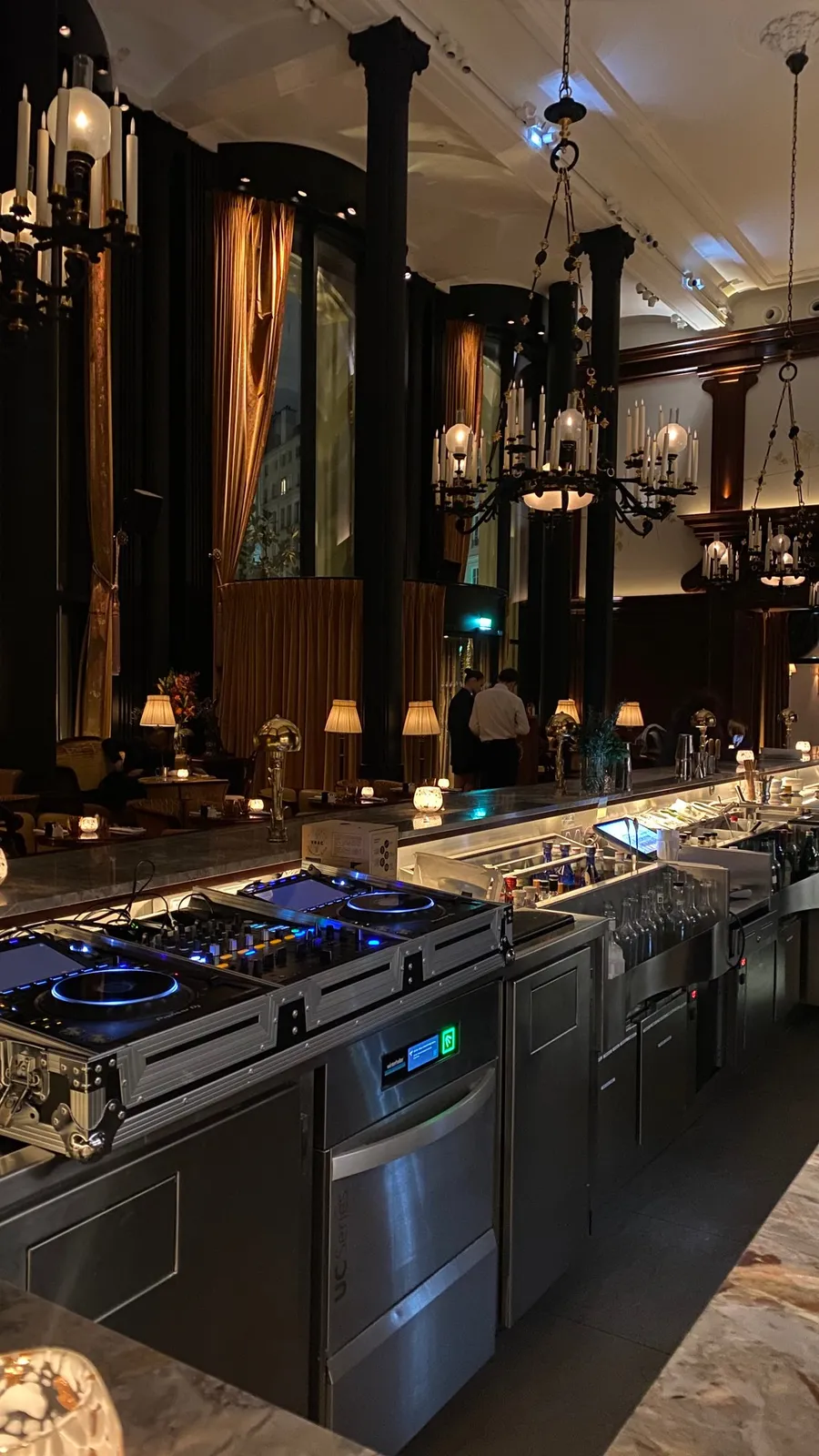 Dark grand restaurant kitchen, chandeliers, blue gas flames