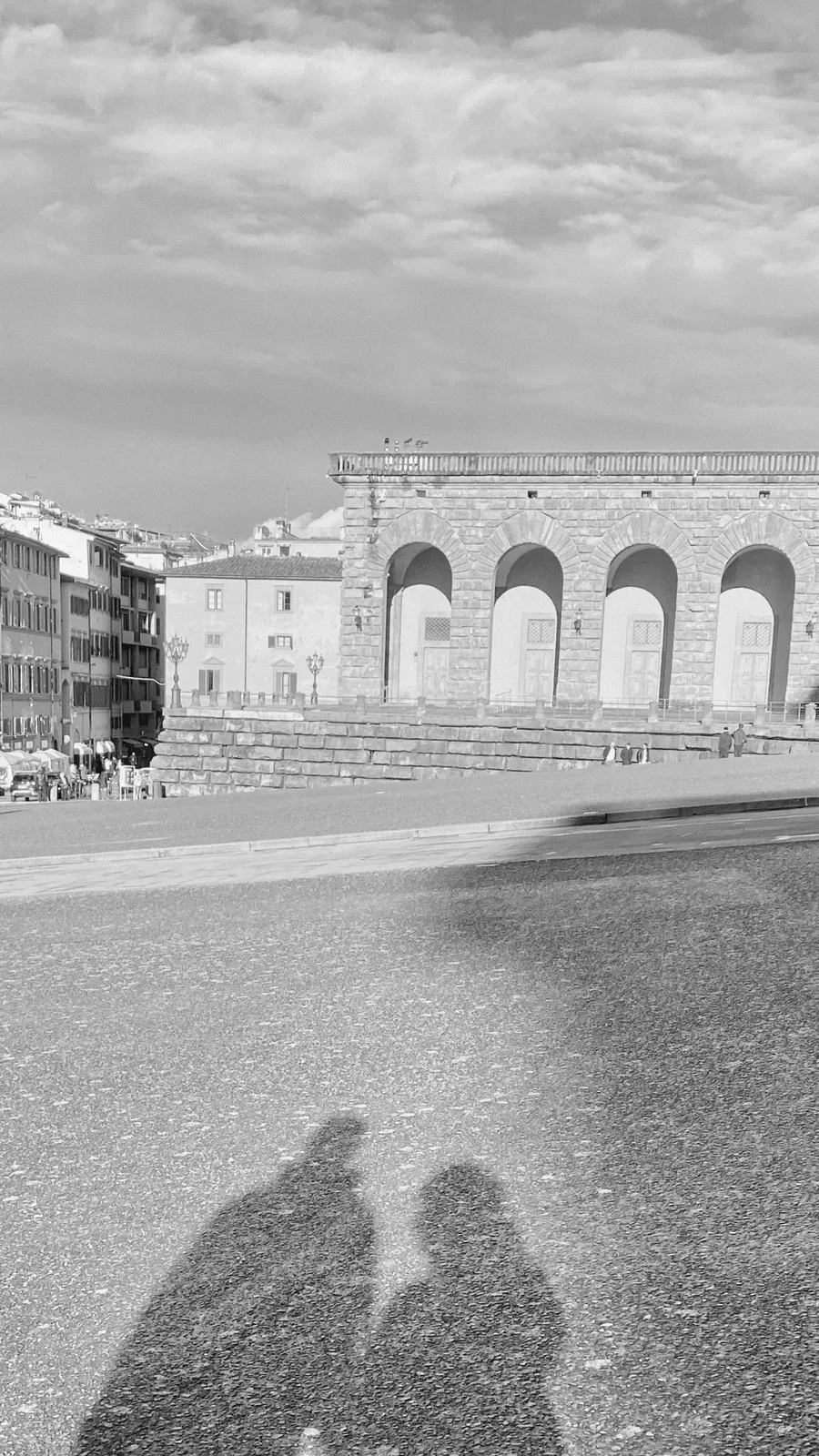 Two long shadows side by side in front of Palazzo Pitti