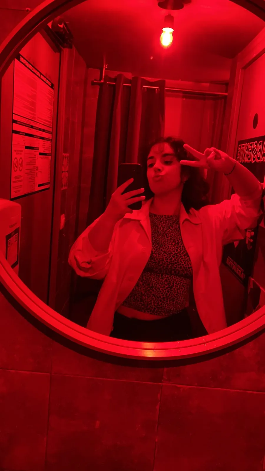 Round mirror selfie bathed in total red light