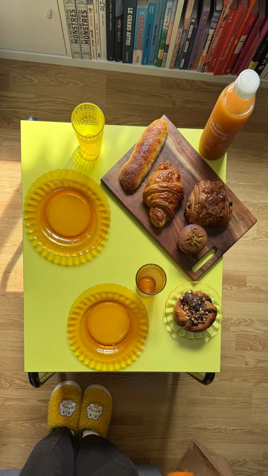 Yellow table, amber glasses, croissants: breakfast from above