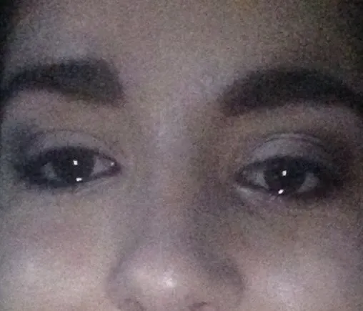 Grainy extreme close-up of eyes and brows, intense stare