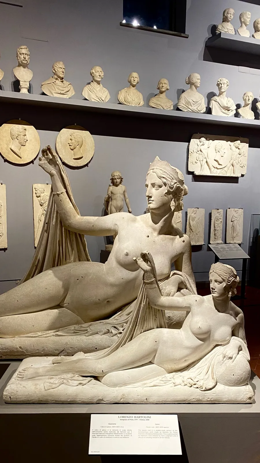 Reclining marble nudes in front of a wall of plaster busts