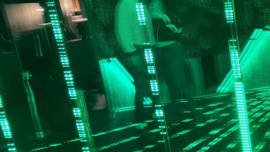 Green LED lines multiplying in an infinity-mirror room