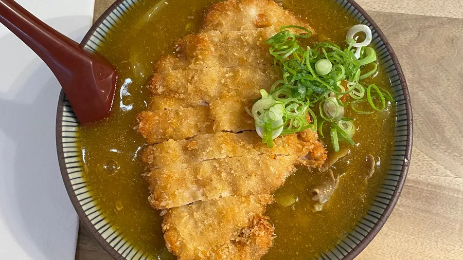 Katsu curry with spring onions, red spoon