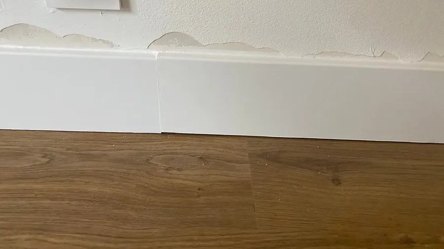 Peeling paint bubbles above a skirting board