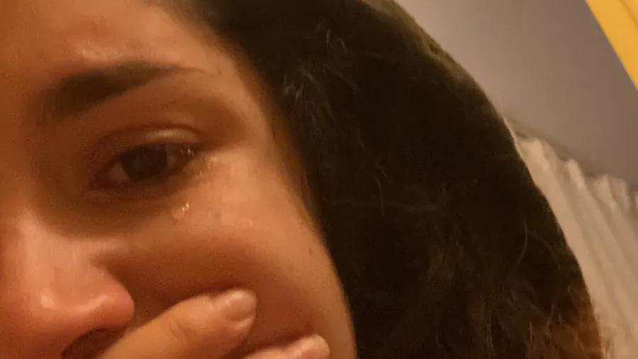 Tearful face, hand over mouth, raw moment