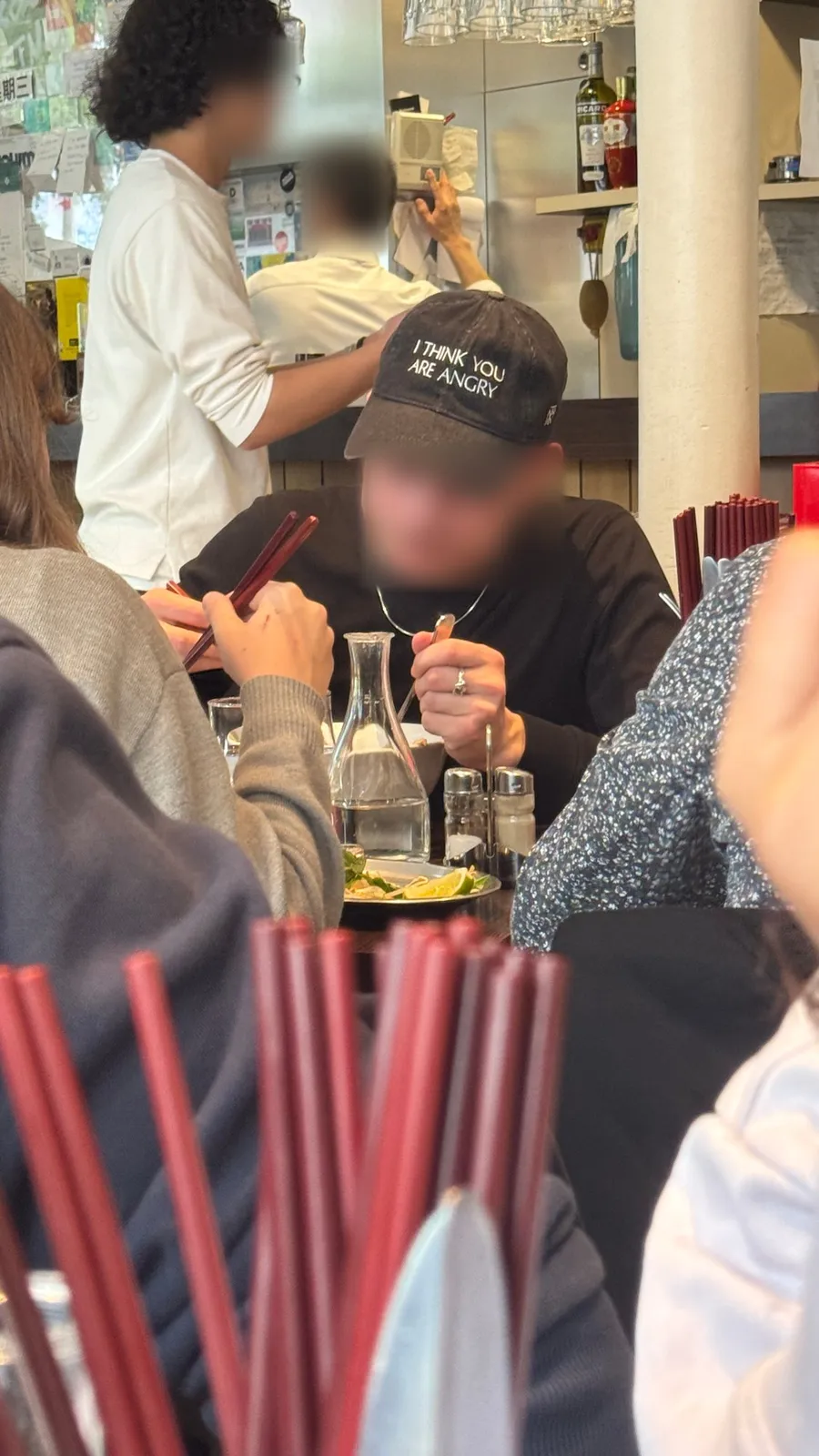 Restaurant scene behind red chopsticks, cap reading 'I think you are angry'