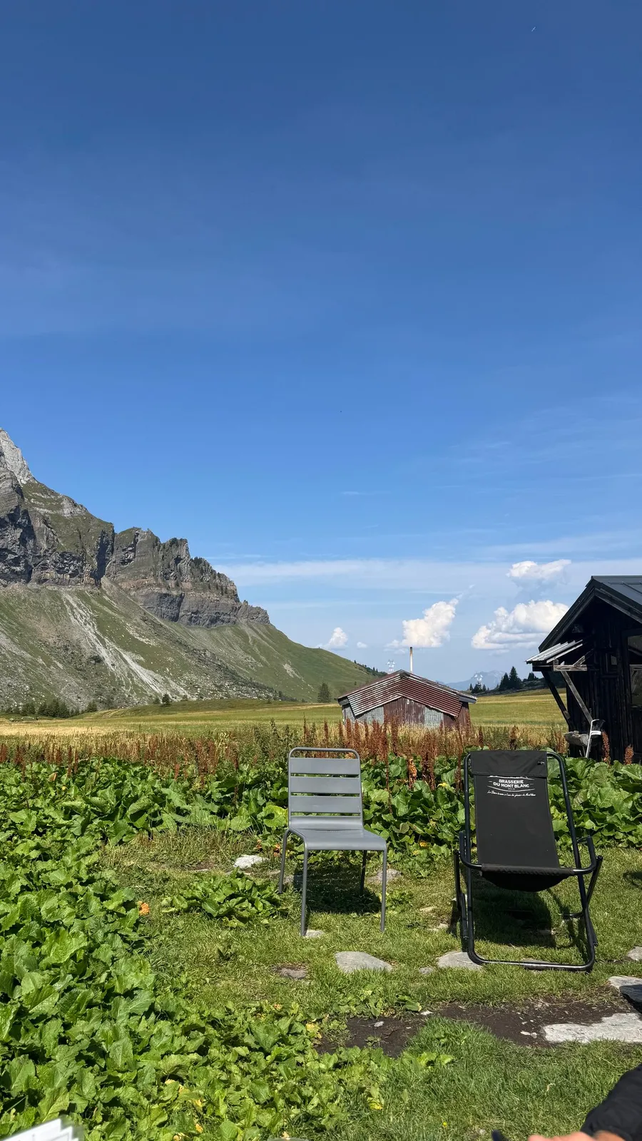 Two empty deckchairs facing the peaks by a chalet