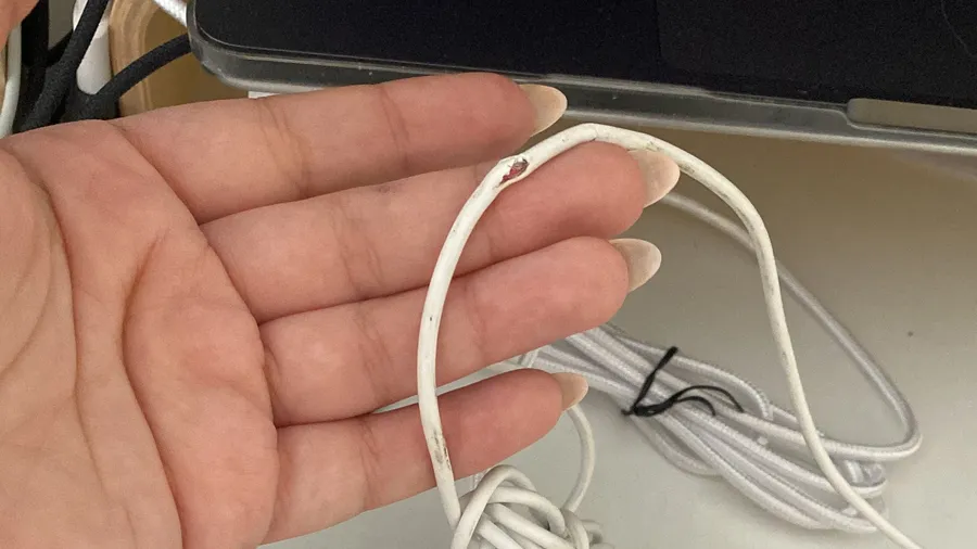 Tiny broken white earbud clip lying in an open palm