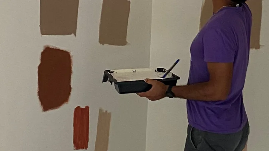 Paint swatches on the wall, someone holding the tray