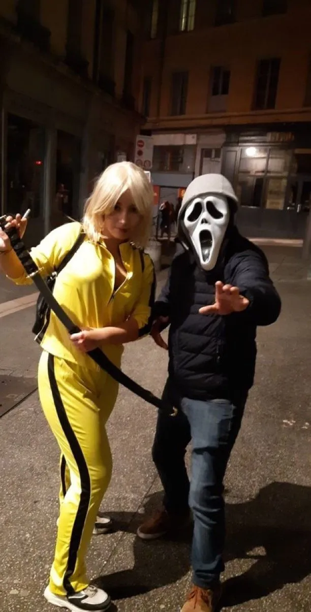 Kill Bill yellow jumpsuit and Scream mask, posing at night