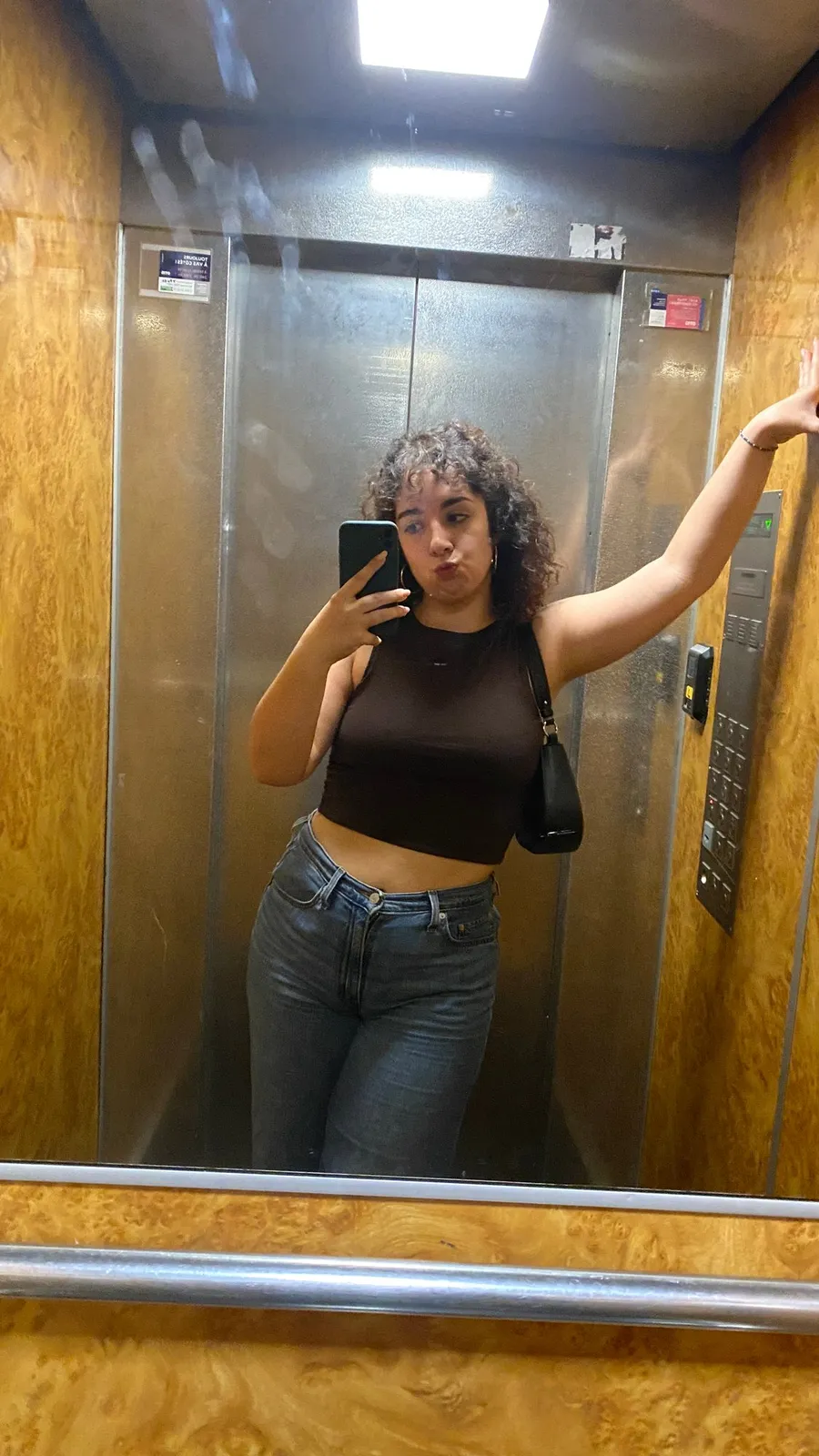 Lift mirror selfie, pout, hand on the wall