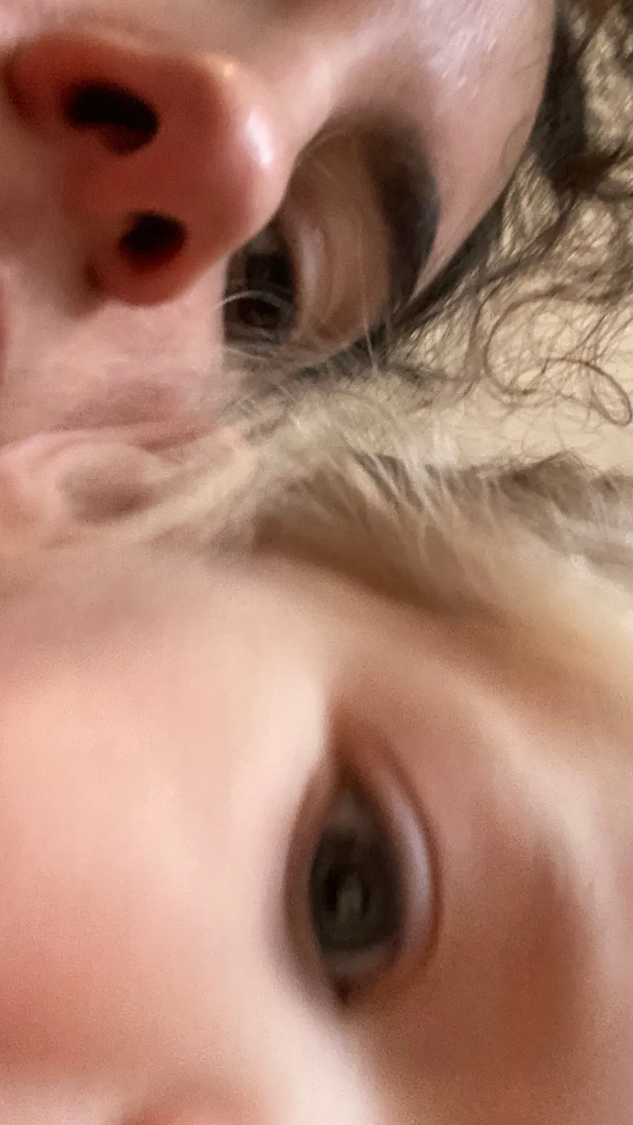 Face pressed close: nostril, one eye, curls