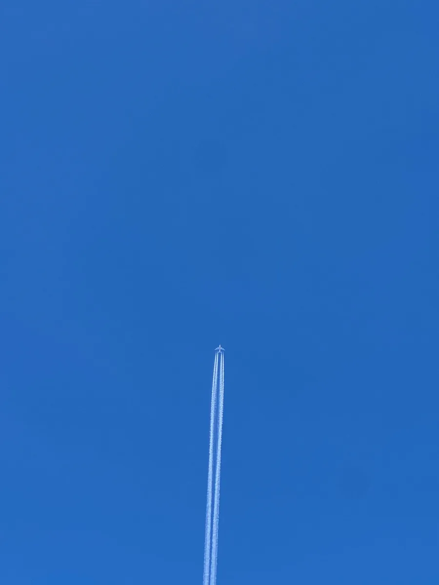 Plane contrail splitting a pure blue sky