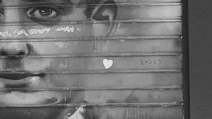 Huge painted eyes on a rolling shutter, a tiny white heart