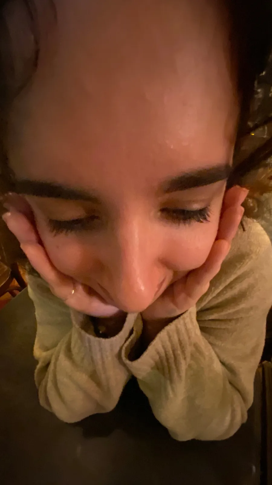 Woman's face cupped in my hands, seen from above, eyes closed