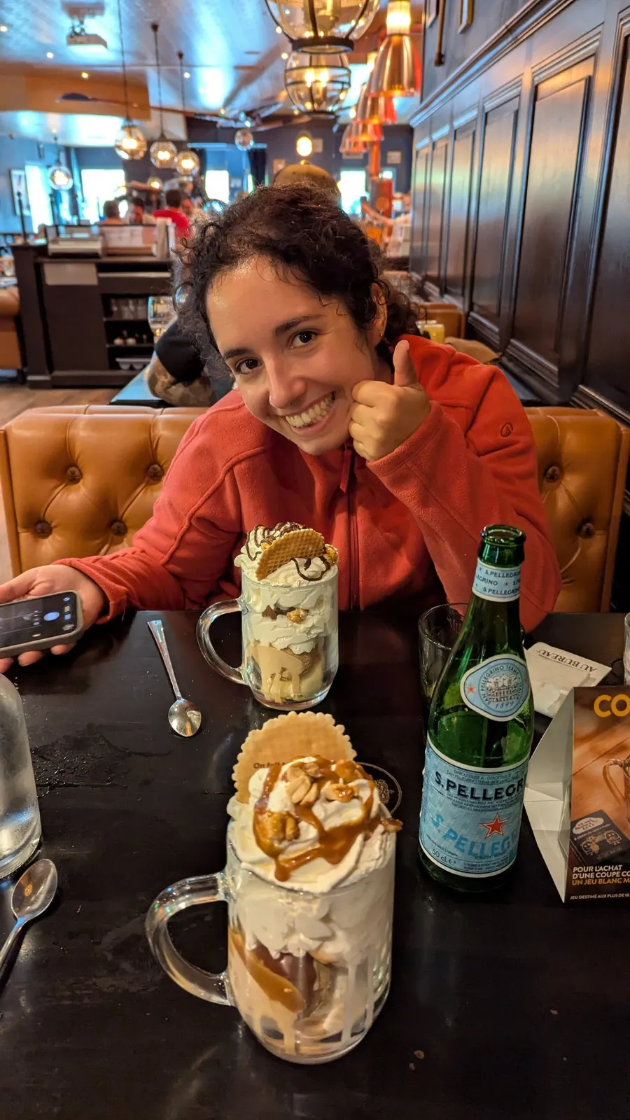 Thumbs up behind two towering caramel milkshakes
