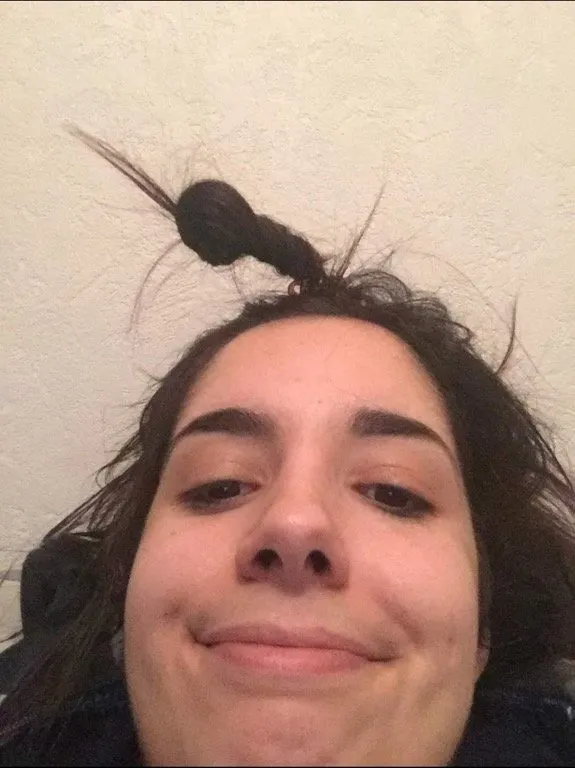 Goofy chin-up selfie, hair in a spiky topknot