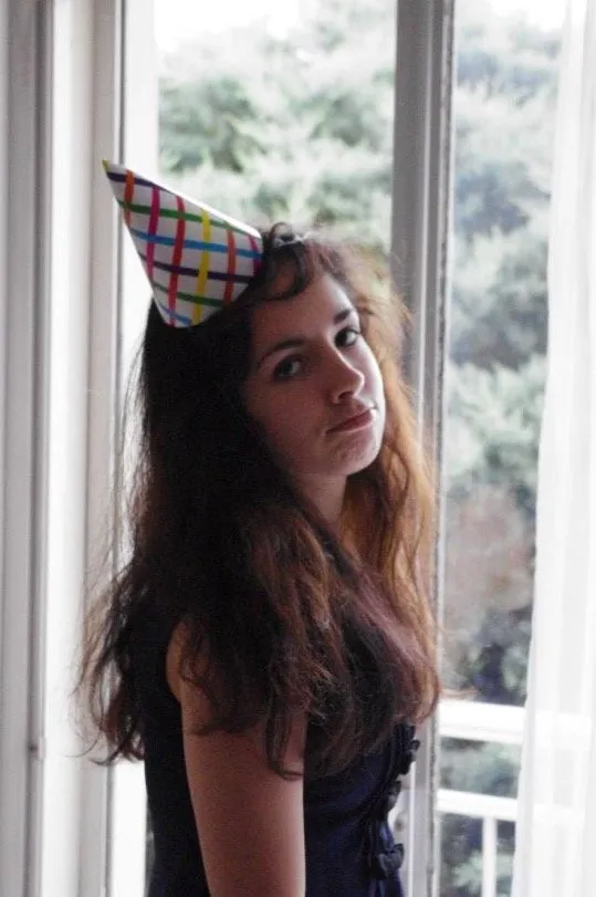 Party hat, deadpan look by an open window