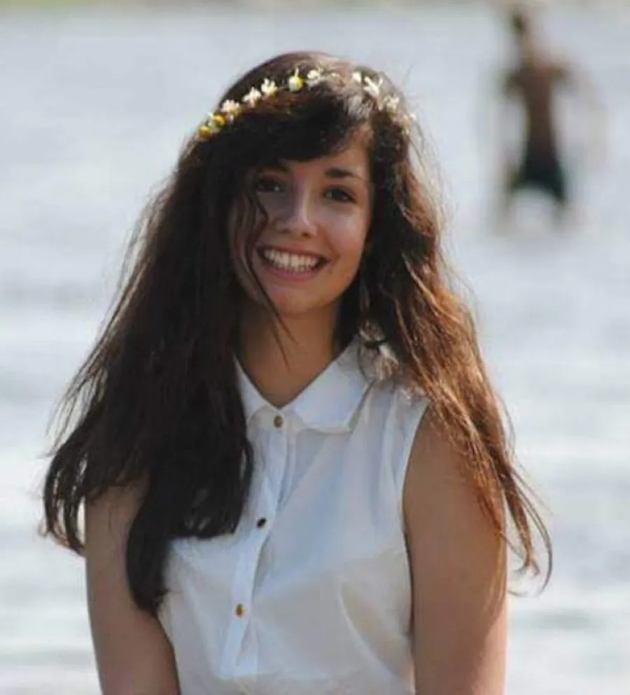 Old photo: flower crown, long hair, sea behind (possibly Manon)