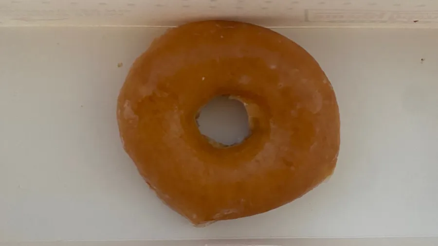 One last glazed doughnut alone on white