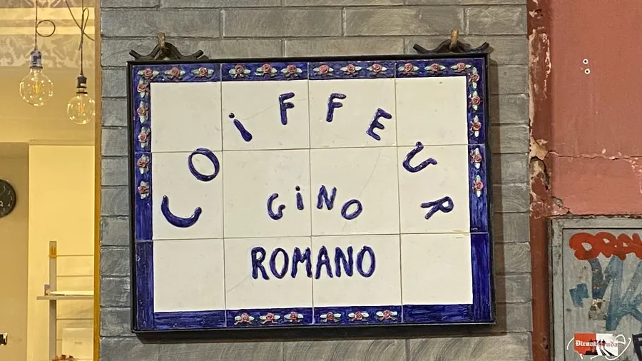 Tiled 'Coiffeur Gino Romano' sign, wobbly blue letters