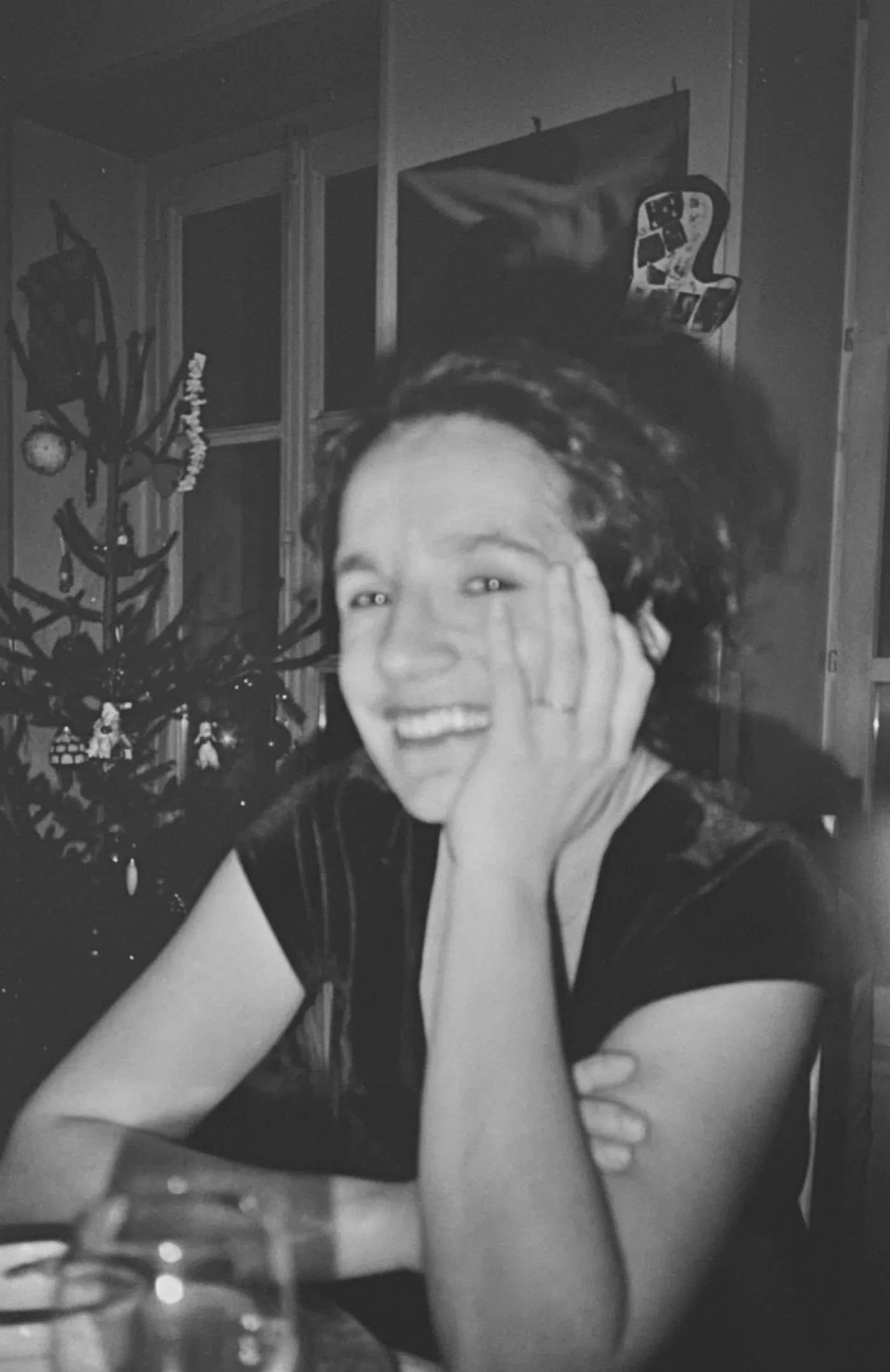Ma mère qui rit, la joue dans la main, un soir de Noël.